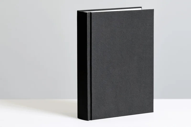 Black hardcover book standing upright on white surface