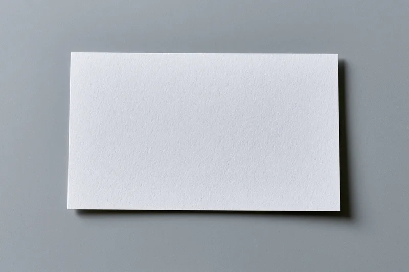 Blank white textured paper card centered on flat gray surface