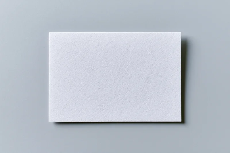 Blank white textured paper card centered on flat gray surface