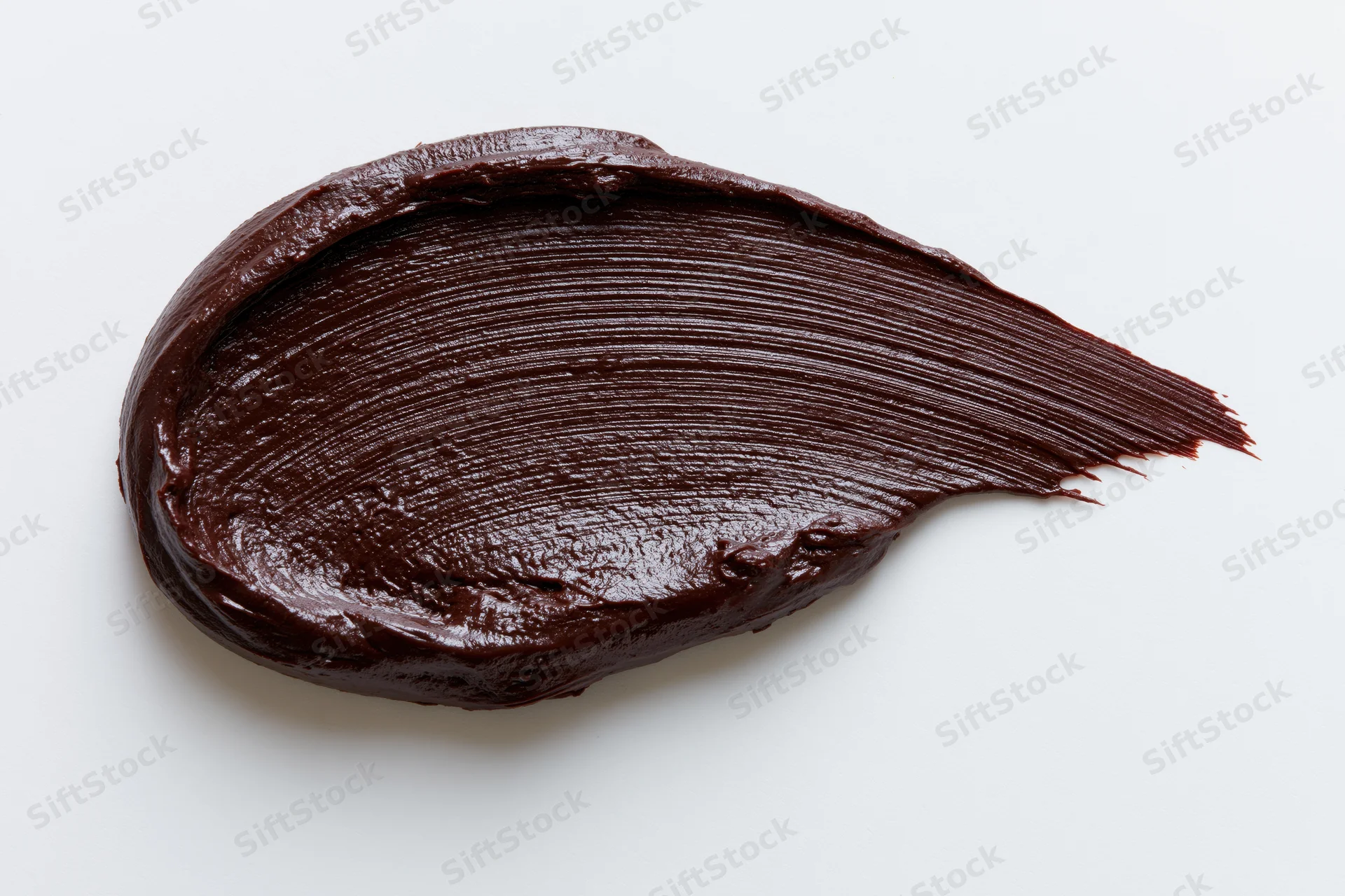 Thick dark chocolate spread smeared across a clean white surface