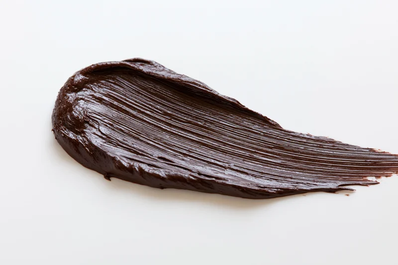 Thick dark chocolate spread swiped across a clean white surface