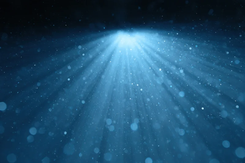Blue light burst radiating upward from a central source in a dark abstract background
