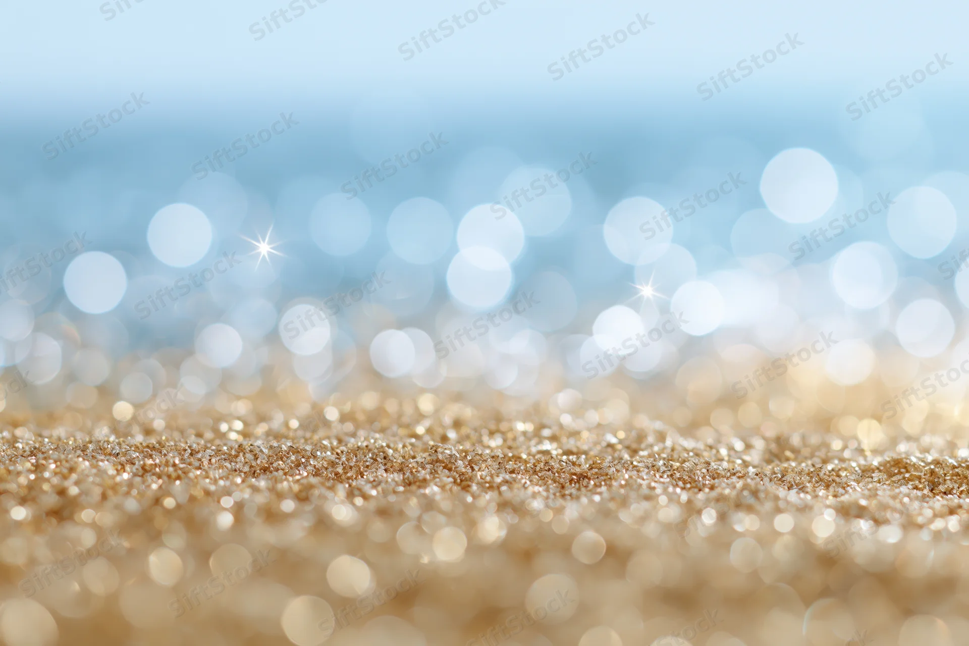 Abstract defocused bokeh background with scattered light orbs and glittery gold surface