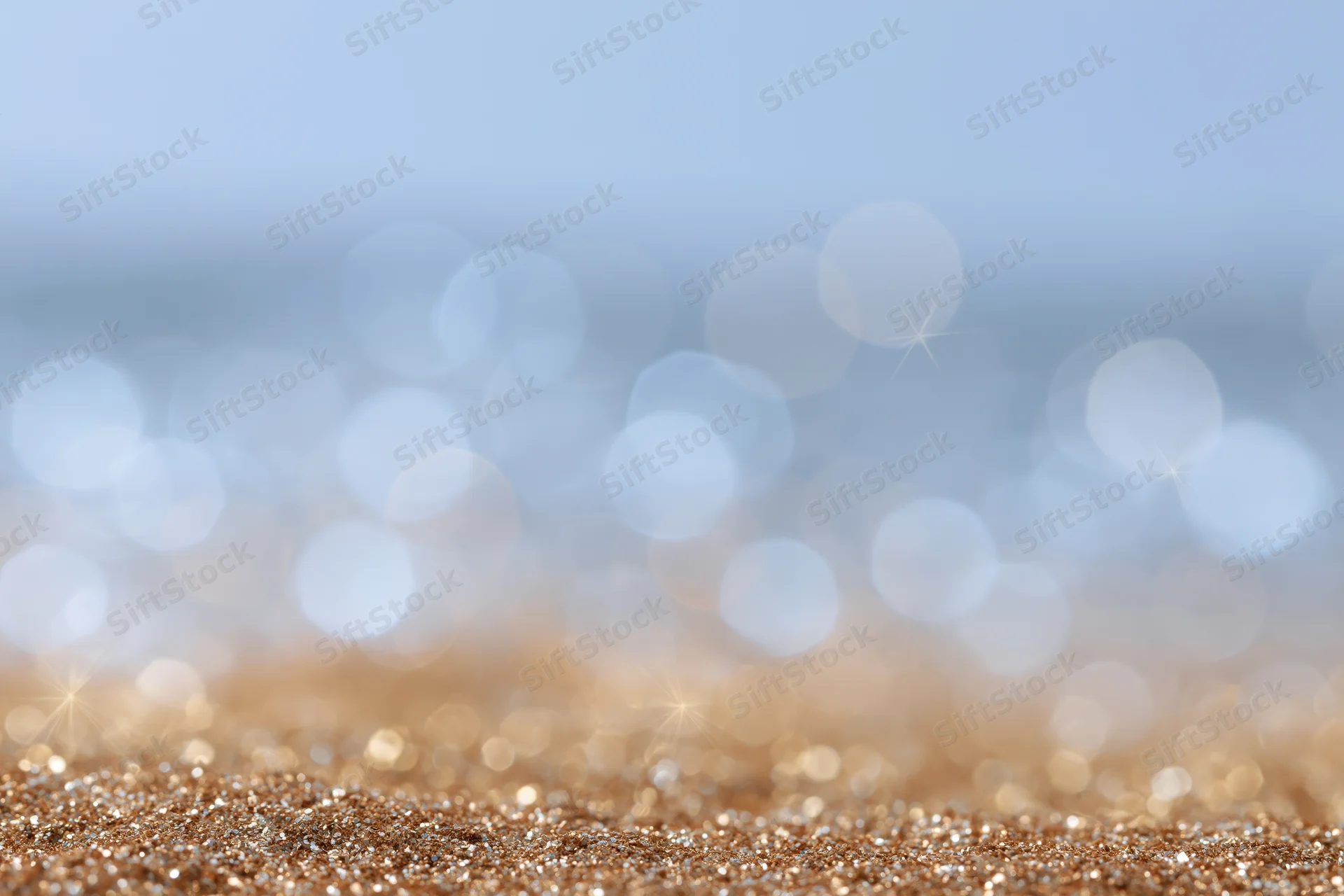 Abstract defocused bokeh background with scattered light orbs and glittery gold foreground