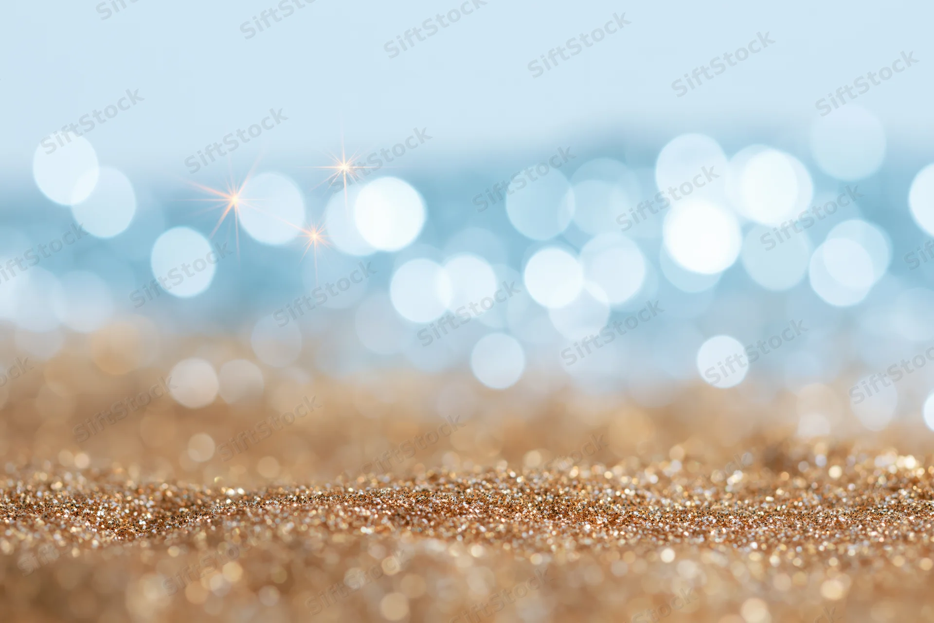 Abstract defocused bokeh background with scattered light orbs and glittery gold surface