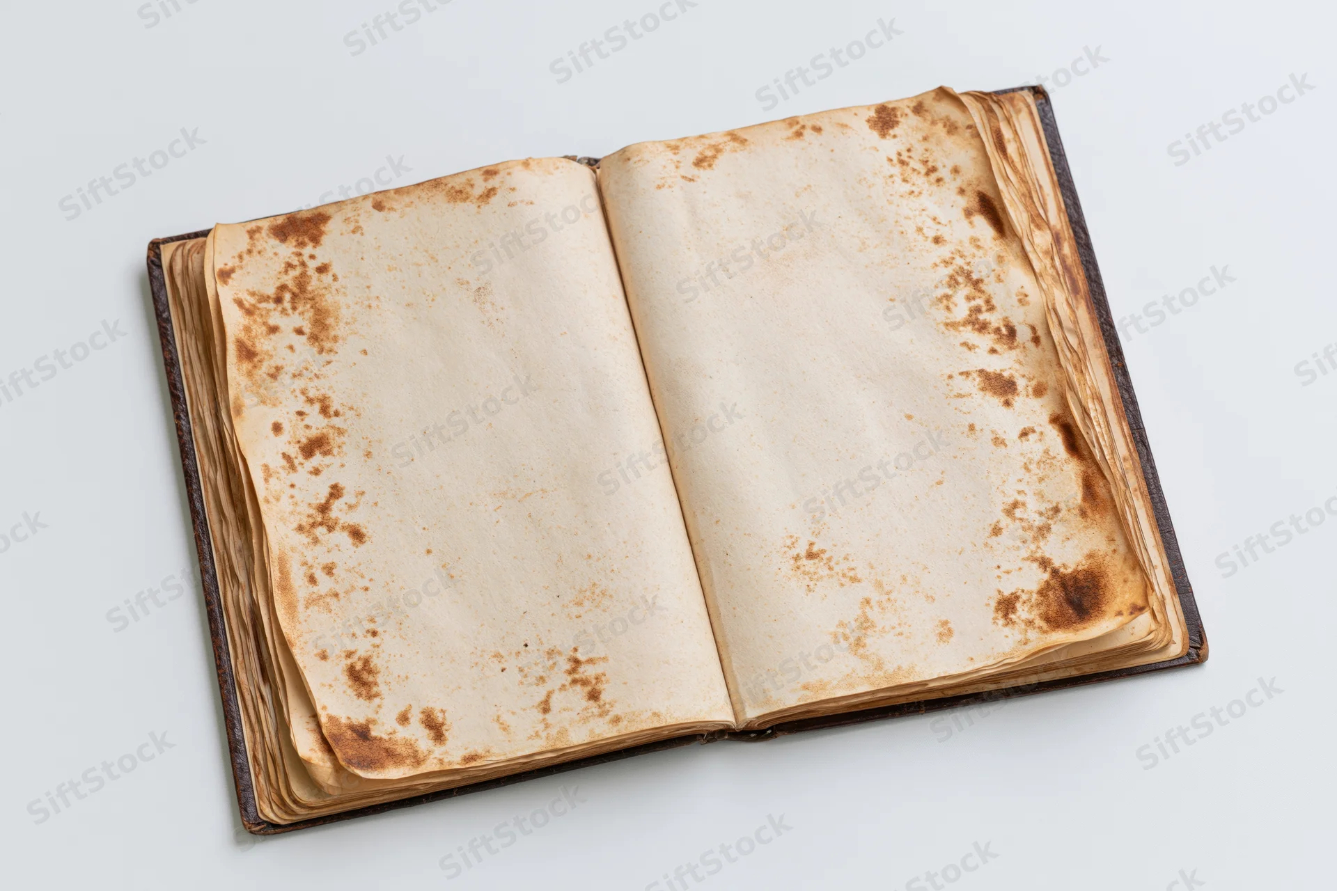 Open antique book with blank aged pages lying flat on white surface