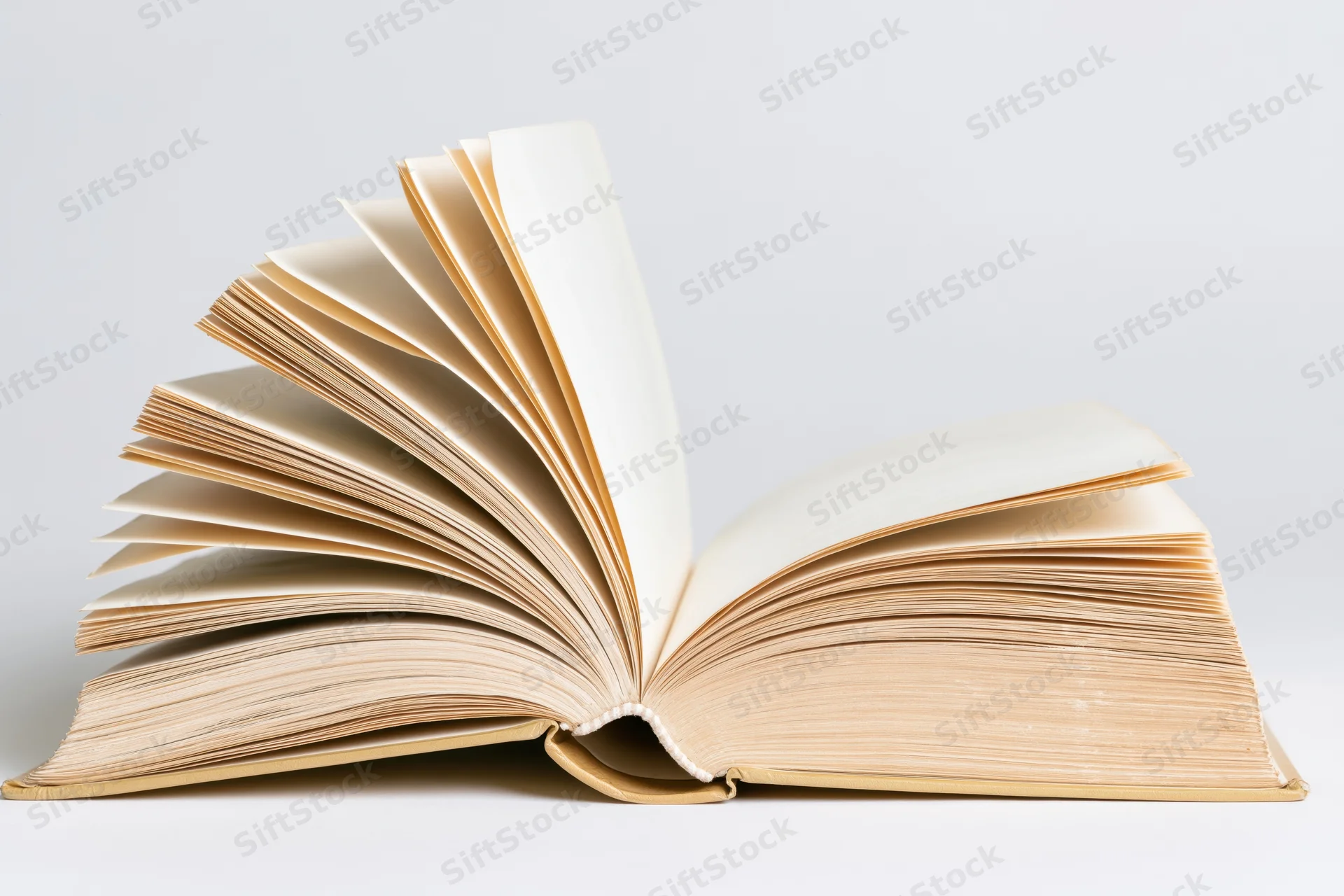 Open hardcover book with pages fanned out on white background