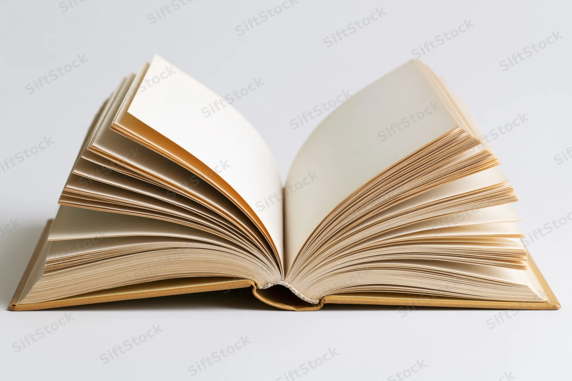 Open hardcover book with pages fanned out and slightly curved on white surface