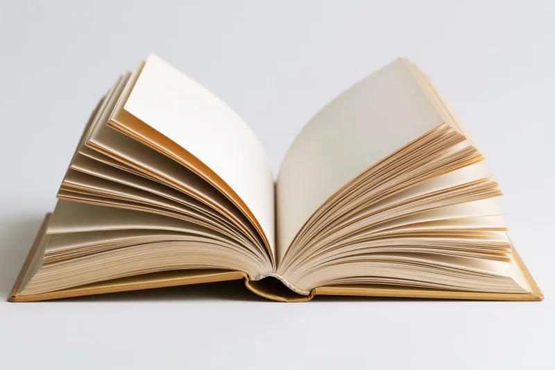 Open hardcover book with pages fanned out and slightly curved on white surface