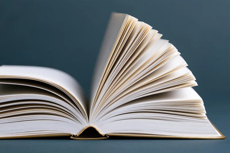 Open hardcover book with pages fanned wide on dark surface