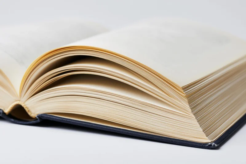 Open hardcover book with pages spread wide on white surface