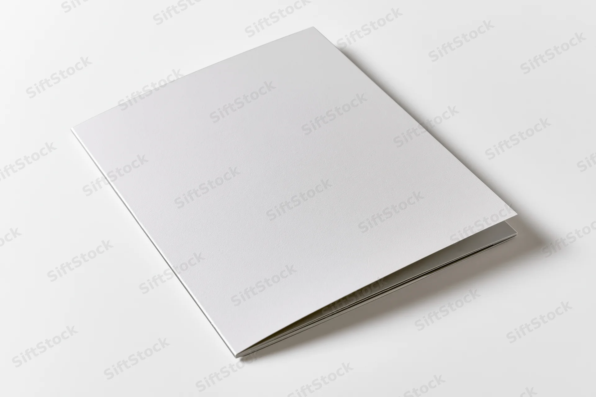 Blank white rectangular brochure lying flat on a white surface