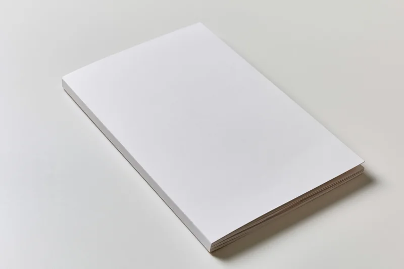 Blank white rectangular brochure lying flat on a light surface with visible pages and clean edges