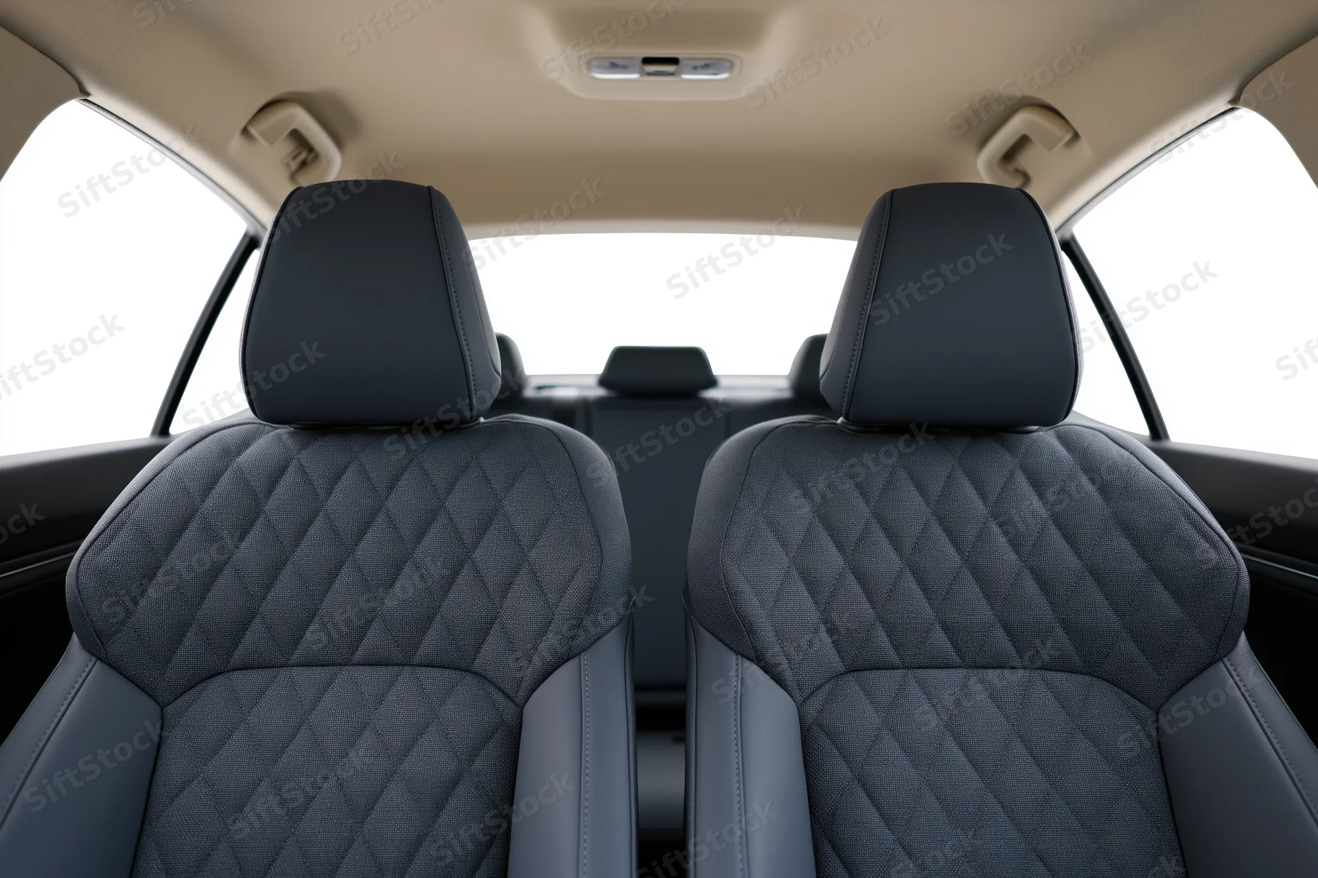 Rear view of car interior showing front seats with quilted upholstery and beige ceiling