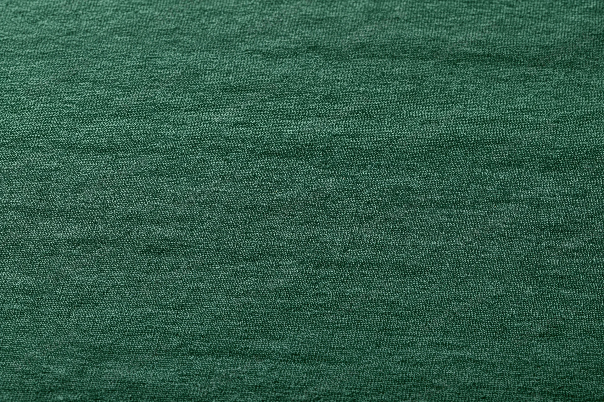 Close-up flat lay of forest green woven fabric filling the frame