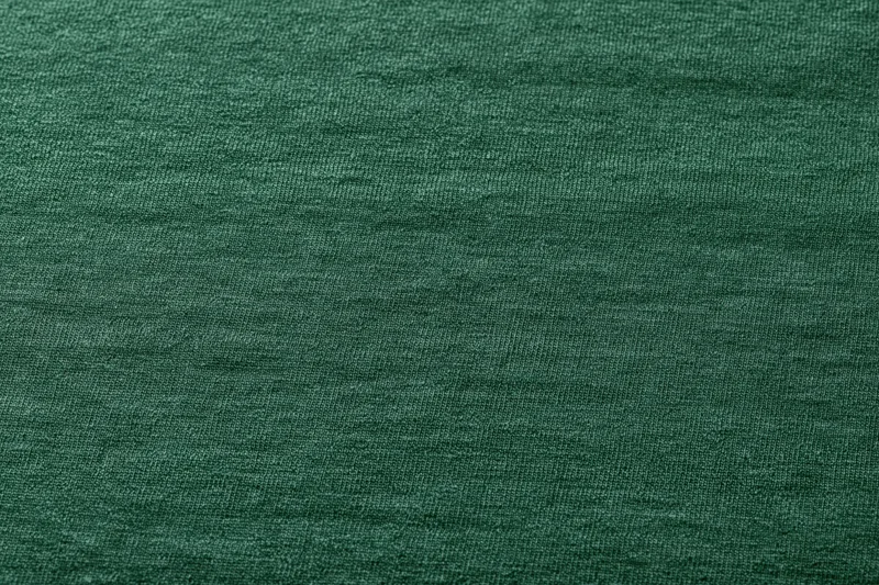 Close-up flat lay of forest green woven fabric filling the frame