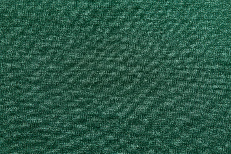 Close-up flat lay of forest green woven fabric filling the frame