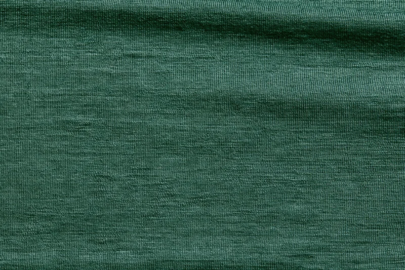 Close-up flat lay of forest green woven fabric filling the frame