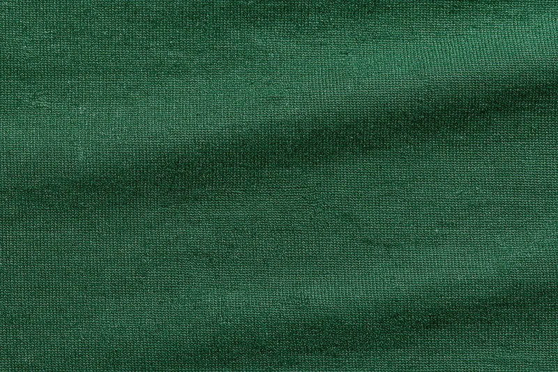 Close-up flat lay of forest green woven fabric filling the frame