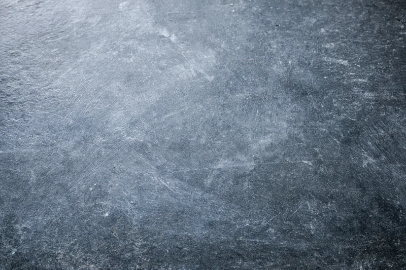 Weathered concrete surface with visible texture and scratches, flat lay view