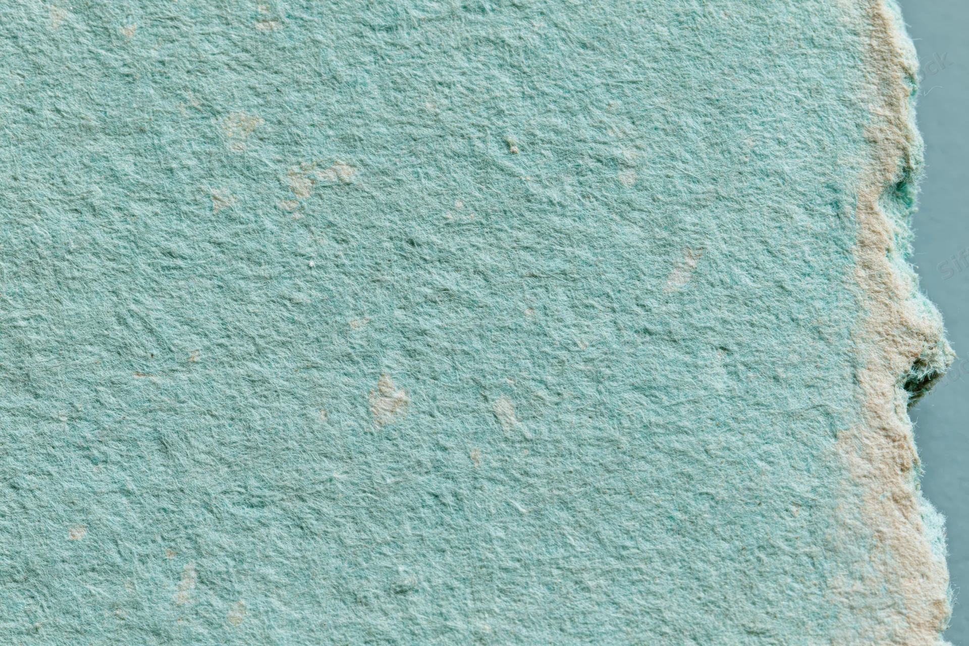 Close-up of aged turquoise paper surface with textured fiber and worn edges in flat lay arrangement
