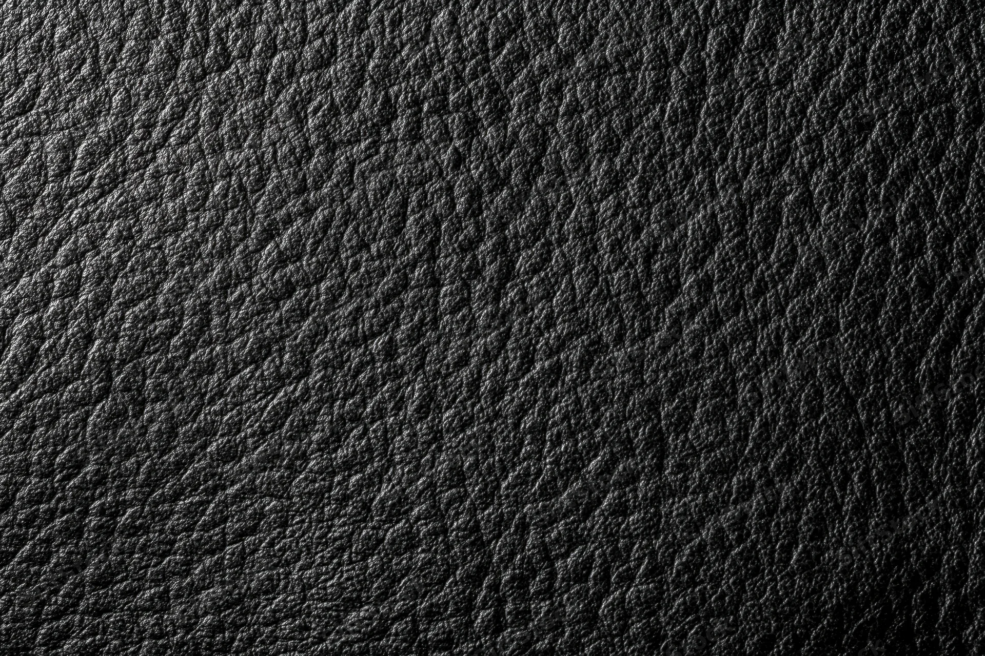 Close-up flat lay of black genuine leather surface filling the frame