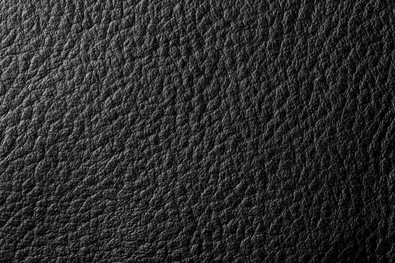 Close-up flat lay of black genuine leather surface filling the frame