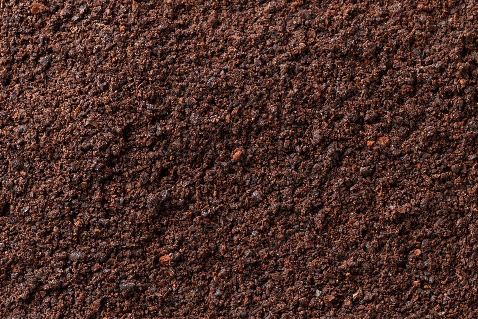 Finely ground coffee spread evenly in a flat lay view filling the frame