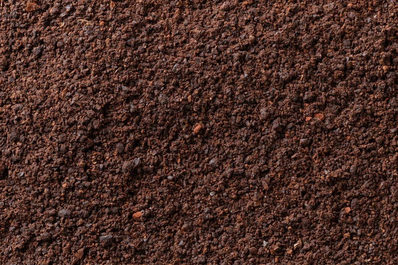 Finely ground coffee spread evenly in a flat lay view filling the frame