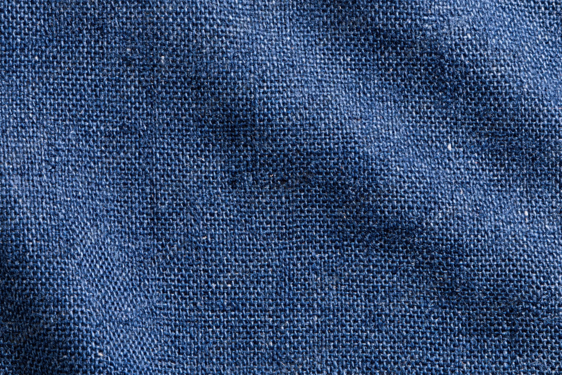 Close-up flat lay of navy blue woven denim fabric filling the frame