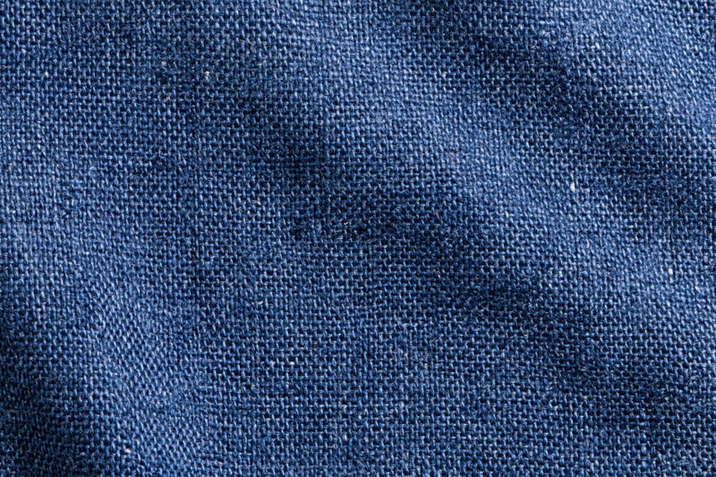 Close-up flat lay of navy blue woven denim fabric filling the frame