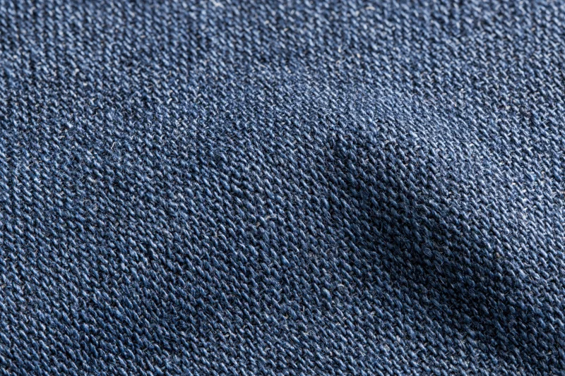 Close-up flat lay of navy blue woven denim fabric filling the frame