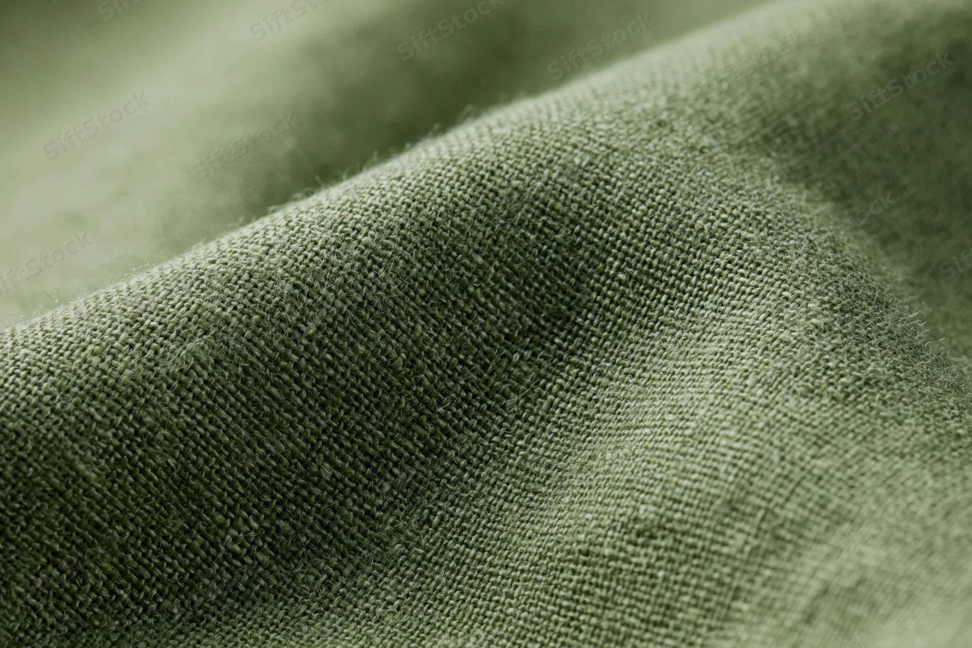 Close-up of olive green linen fabric with visible weave texture filling the frame