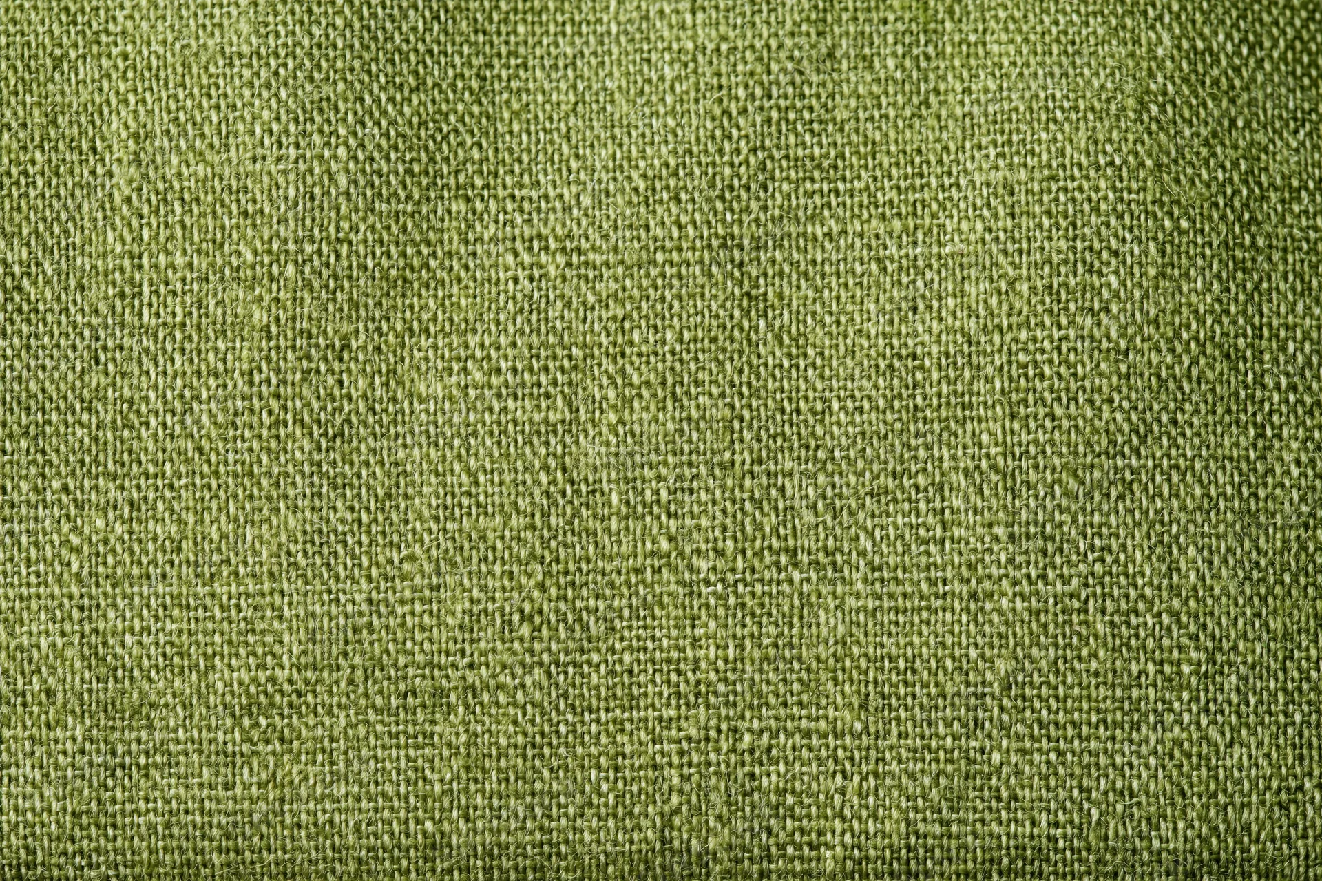 Close-up flat lay of olive green linen fabric filling the frame