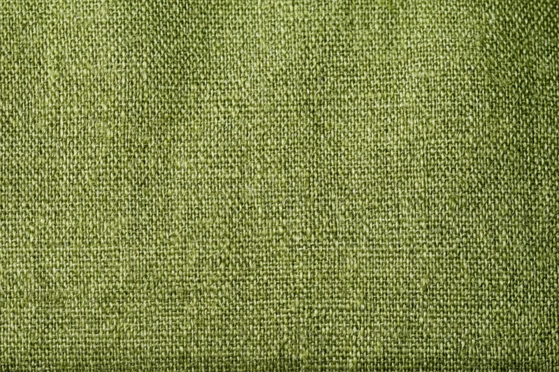 Close-up flat lay of olive green linen fabric filling the frame