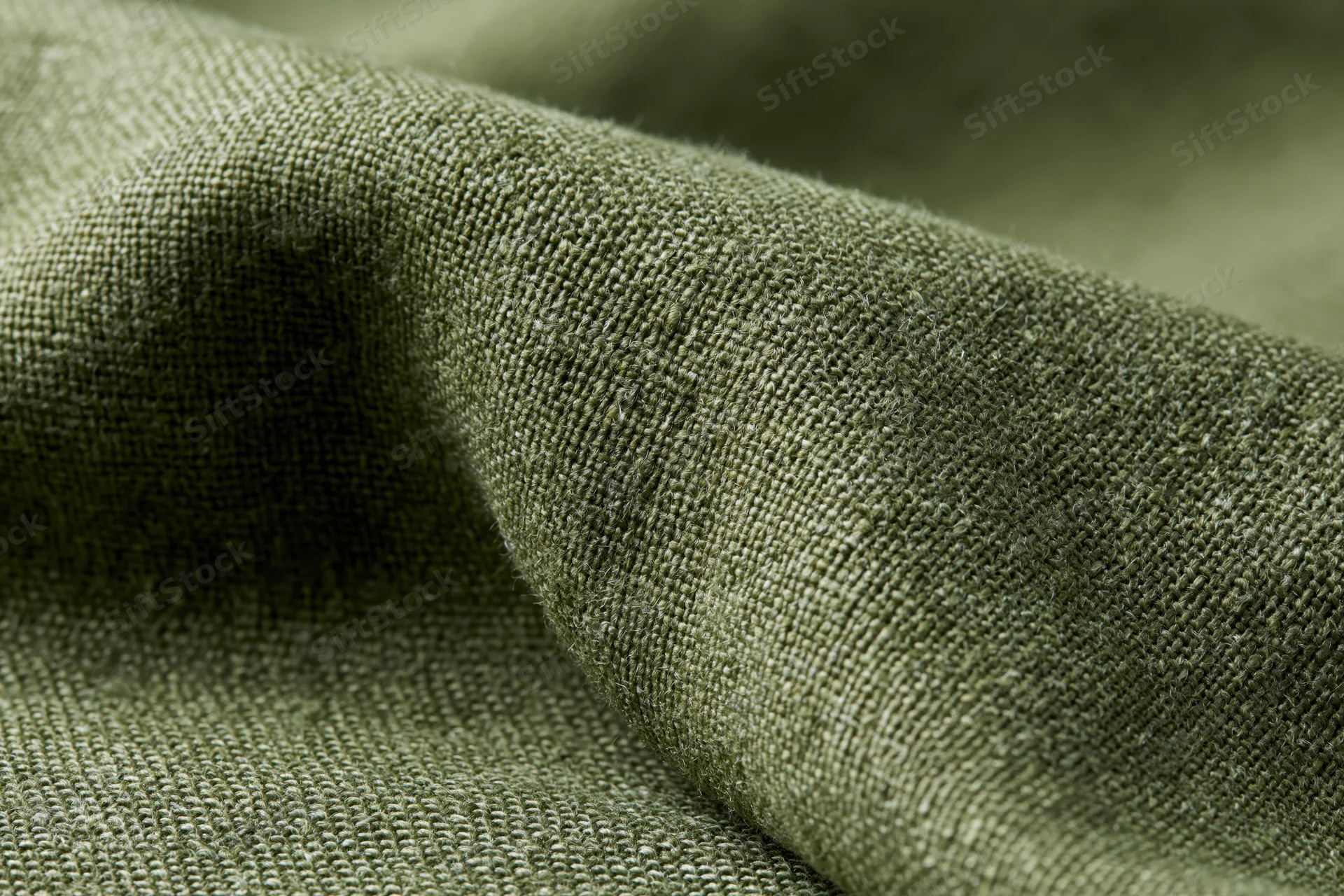 Close-up of olive green linen fabric with visible weave and folds filling the frame