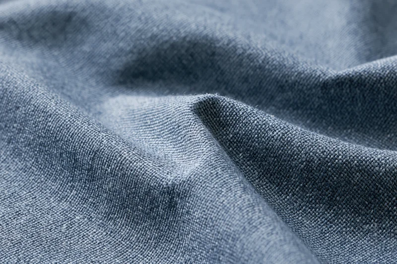 Close-up of blue woven fabric with visible texture and folds filling the frame