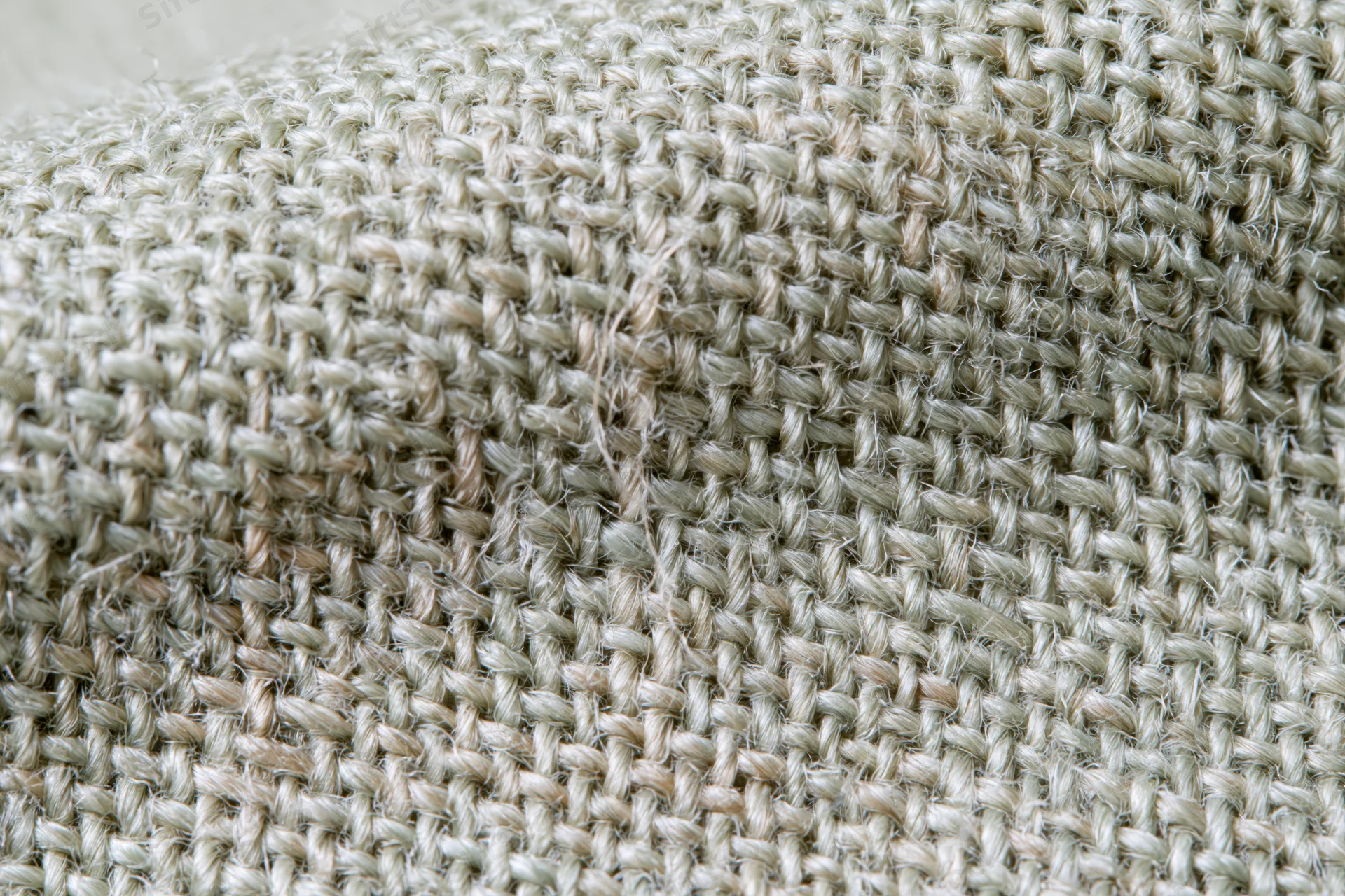 Close-up of woven linen fabric filling the frame in a flat lay arrangement
