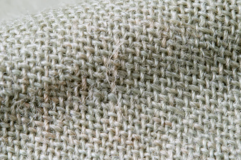 Close-up of woven linen fabric filling the frame in a flat lay arrangement