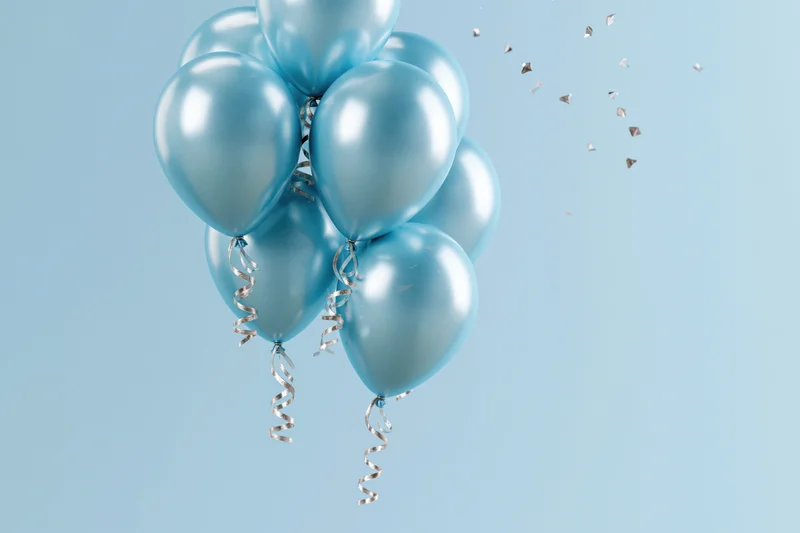 Cluster of shiny cyan helium balloons with curling silver ribbons floating against a light blue background with scattered confetti