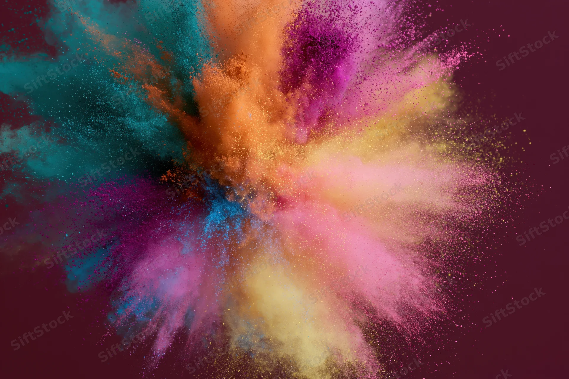 Colorful holi powder bursting outward in a dynamic explosion against a dark background