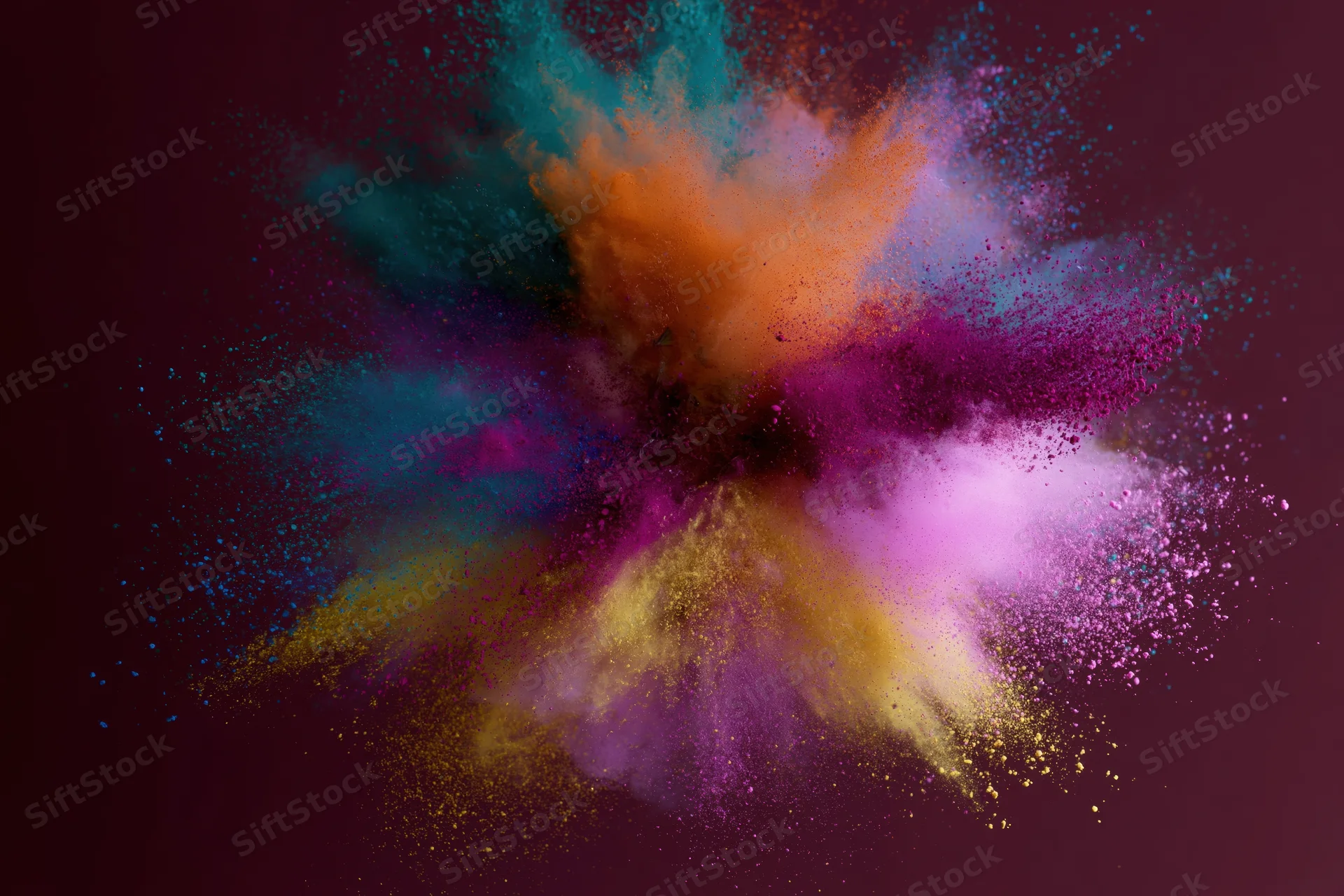 Colorful holi powder exploding outward in a burst of vibrant pigments against a dark background