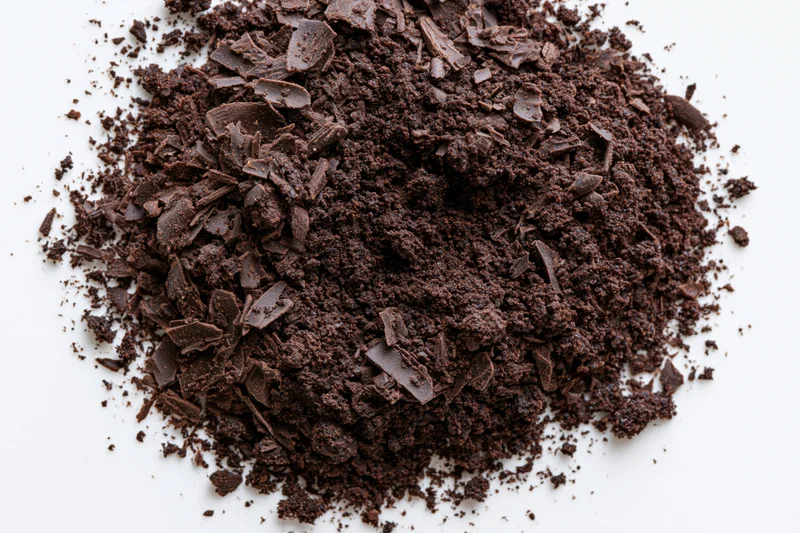 Chocolate shavings and crumbles scattered across white surface