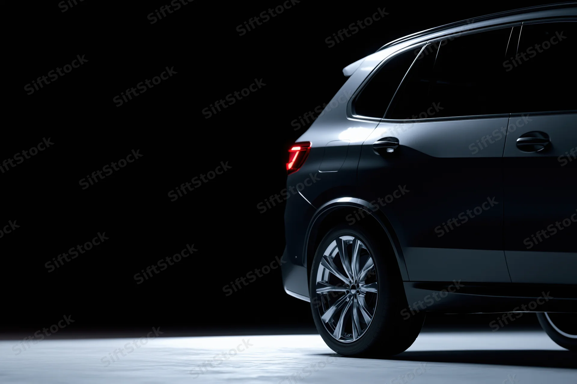 Dark grey luxury suv shown from rear threequarter angle in studio lighting with copyspace