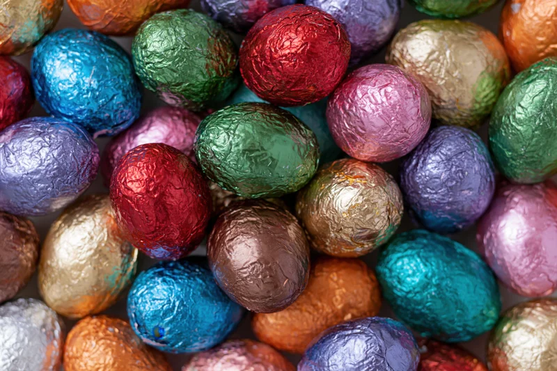 Foil-wrapped chocolate easter eggs packed tightly together