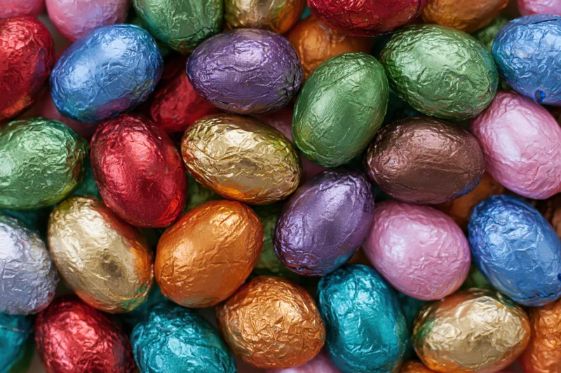 Foil-wrapped chocolate easter eggs packed tightly together