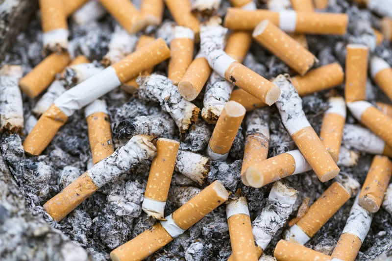 Cigarette butts piled in a public ashtray