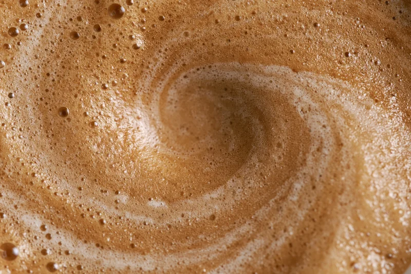 Coffee crema swirling in a cup viewed from above