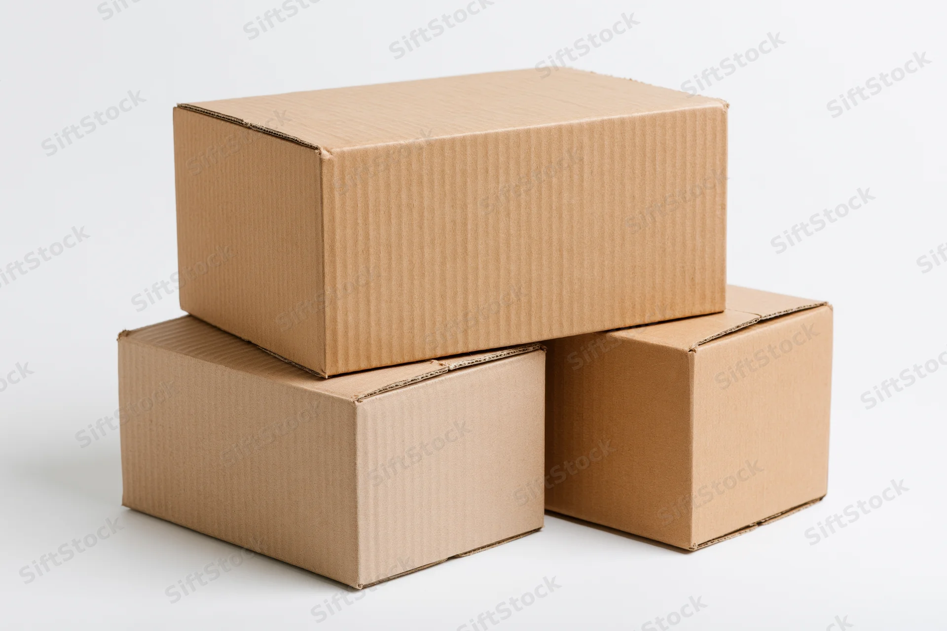 Three plain cardboard boxes stacked in a pyramid formation on a white surface