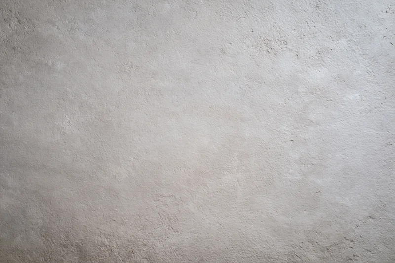 Flat concrete wall surface filling the frame with rough texture and neutral gray tone